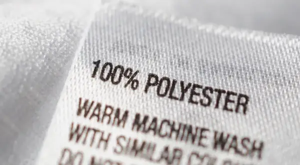 Etikett zeigt "100% POLYESTER". Ist Polyester gut? Ja, es ist pflegeleicht und langlebig.
