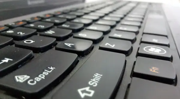 Primer plano de un teclado de portátil. La tecla Shift está en el centro, lista para escribir en mayúsculas.