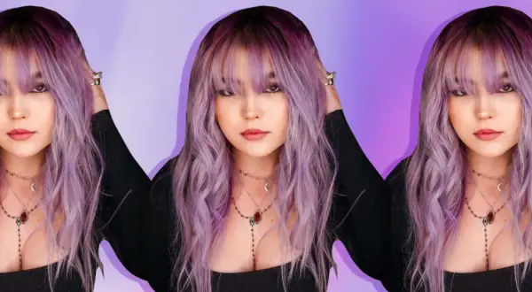 Una joven con cabello ondulado en una gama de violetas, con flequillo y collares delicados.