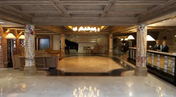 Eleganckie hotelowe lobby z fortepianem, kanapami i recepcją.