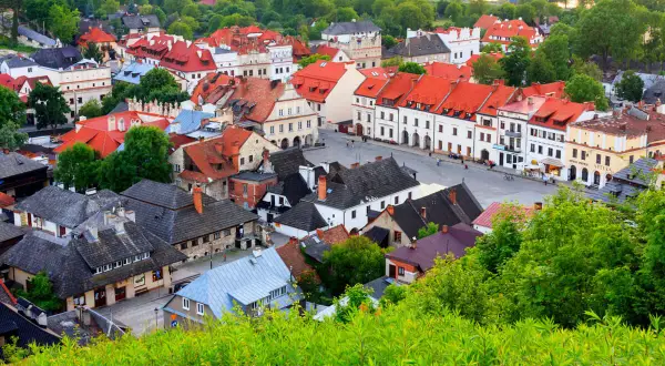 Urokliwe miasteczko z czerwonymi dachami, idealne na weekend w Lubelskiem. Zieleń otacza zabytkowe kamienice.
