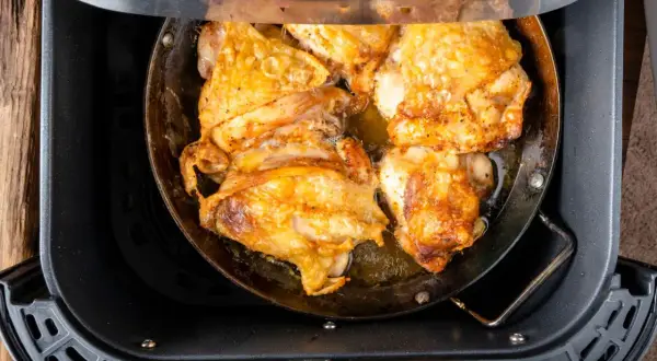 Pechuga de pollo dorada y jugosa cocinándose en una freidora de aire.