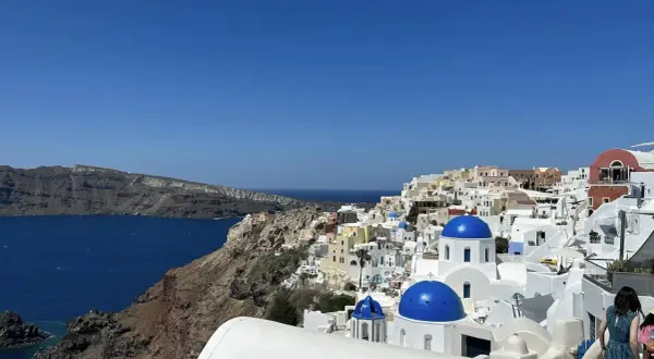 Widok na białe domy z niebieskimi kopułami na Santorini. Idealne miejsce na niezapomniane wycieczki.