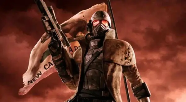 Żołnierz w pancerzu z maską i karabinem, za nim powiewa flaga z napisem "NEW CA". Wygląda jak z gry Fallout New Vegas 2.