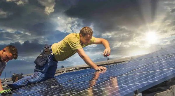Instalatorzy montują panele fotowoltaiczne na dachu. To kluczowy etap w procesie fotowoltaika krok po kroku, zapewniający przyszłą energię ze słońca.