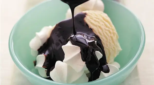 En skål med vaniljglass och visp täcks av en härlig, sockerfri chokladsås som ringlas över.