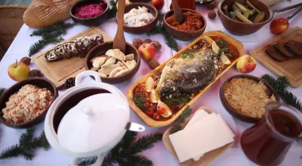 Wigilijny stół ugina się pod ciężarem potraw: karp, pierogi, kapusta, barszcz i inne przysmaki tworzą bogatą listę 12 potraw wigilijnych.