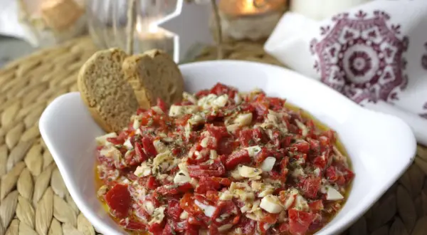 Deliciosa ensalada de pimientos asados con trozos de huevo duro y hierbas, servida con pan tostado.