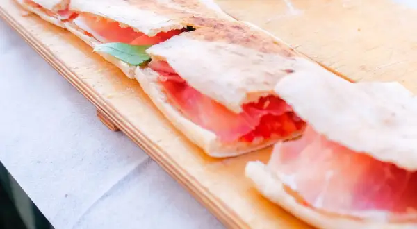 Paposcia Peschici, focaccia ripiena di prosciutto crudo e pomodoro, un sapore autentico del Gargano.
