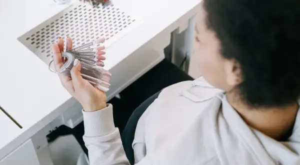 En gravid kvinna väljer nagellack från en provkollektion.
