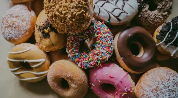 Kolorowe pączki z posypką, lukrem i cukrem pudrem. Każdy kusi swoim wyglądem, a ich pączek kcal może przyprawić o zawrót głowy.