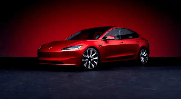 Un Tesla Model 3 rojo brillante, listo para demostrar su bajo consumo.