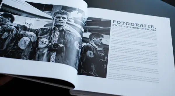Mężczyzna z aparatem fotograficznym na szyi, w stroju z symbolem aparatu. Czy to on wynalazł fotografię?