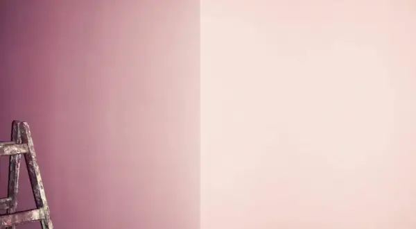 Alte Leiter steht vor einer Wand, die in zwei Rosatöne geteilt ist. Perfekt für das **Wandfarbe mischen** für ein neues Projekt.