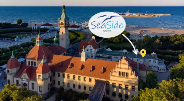 Widok z lotu ptaka na Sopocką plażę, morze, molo i zabytkowe budynki.
