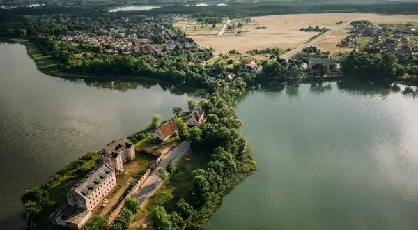 Widok z lotu ptaka na Ełk: jezioro, zabudowania i tereny zielone.