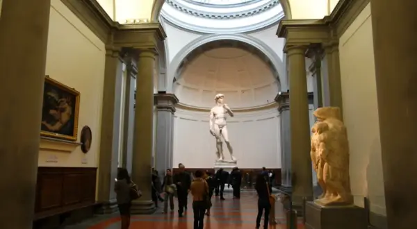 Beeld van David, een meesterwerk uit de renaissance periode, in een museum met bezoekers.