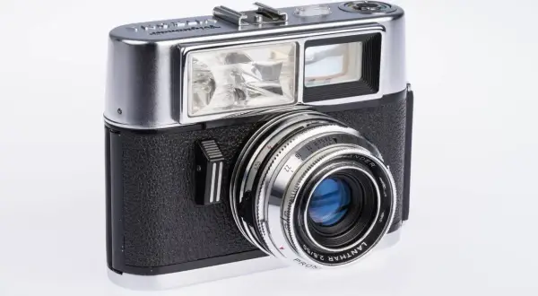 Klasyczny, srebrno-czarny aparat Voigtländer. Ten pierwszy aparat fotograficzny z lat 50. ma charakterystyczny obiektyw i wbudowaną lampę błyskową.