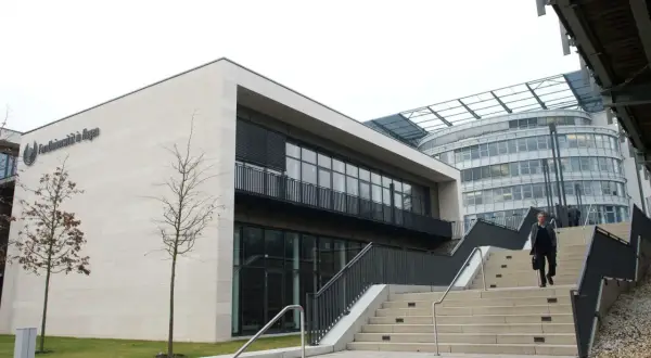 Moderne Architektur der FernUni in Hagen, NRW. Eine Person steigt eine breite Treppe hinauf.
