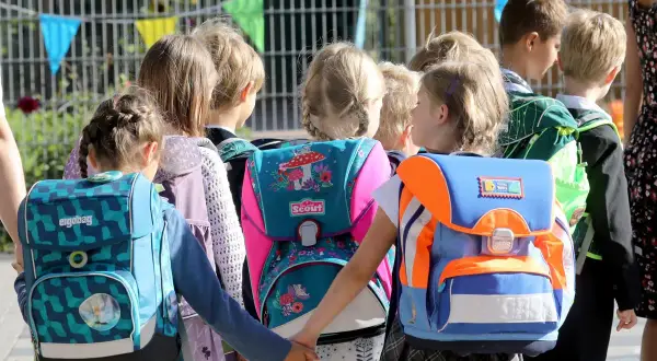 Kinder mit bunten Schultüten und Rucksäcken, bereit für den einschulung erster schultag.