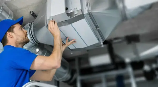 Installatör byter filterduk i ventilationssystem. Ren luft är viktigt för hälsan.