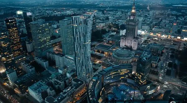 Widok z góry na nocną panoramę Warszawy, z wieżowcami i Pałacem Kultury. Marzysz o takich widokach? Kup bilety na Varso Tower!