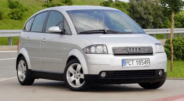 Srebrny Audi A2, kompaktowy samochód z charakterystycznymi, zaokrąglonymi liniami, prezentuje swoje a2 wymiary na tle zieleni.