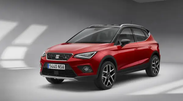Czerwony Seat Arona z czarnym dachem, gotowy na miejskie przygody.