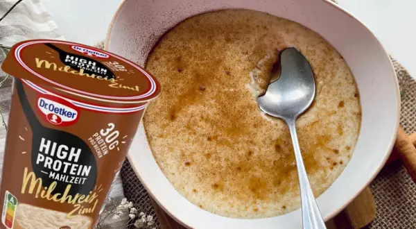 Schüssel mit Milchreis mit Zimt, daneben ein Becher "High Protein Milchreis Zimt" von Dr. Oetker.