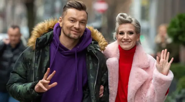 Sylwia Grzeszczak i Liber uśmiechają się do obiektywu, ona macha ręką, on pokazuje znak pokoju.