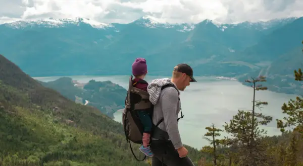 Ojciec z dzieckiem w nosidle na tle gór. Gdzie w Tatry? To pytanie zadaje sobie wielu, ale ten widok zapiera dech w piersiach.