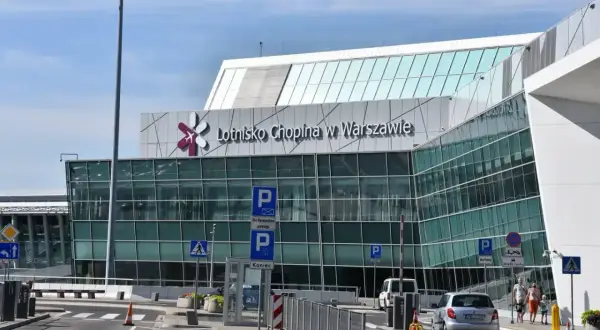 Nowoczesny budynek Lotniska Chopina w Warszawie. Znak "Koniec" i parkingowe wskazują, jak dojechać na lotnisko Chopina.