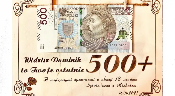 Drewniana tabliczka z banknotem 500 zł i napisem "500+".