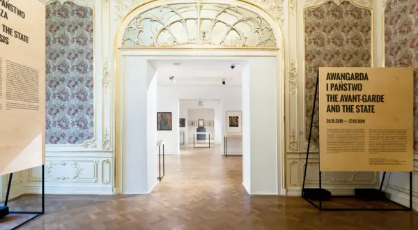 Wnętrze muzeum z tablicami informacyjnymi i widokiem na sale wystawowe.