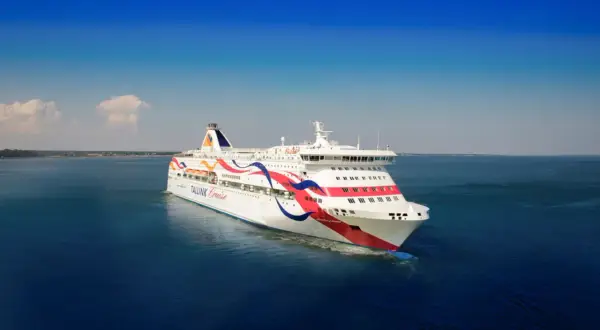 Stor färja, en Tallink-båt, glider fram på det blå havet under en klarblå himmel.