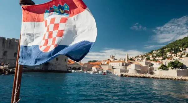 Chorwacka flaga na tle Dubrownika. Planujesz podróż? Sprawdź, co zabrać do Chorwacji jadąc samochodem.