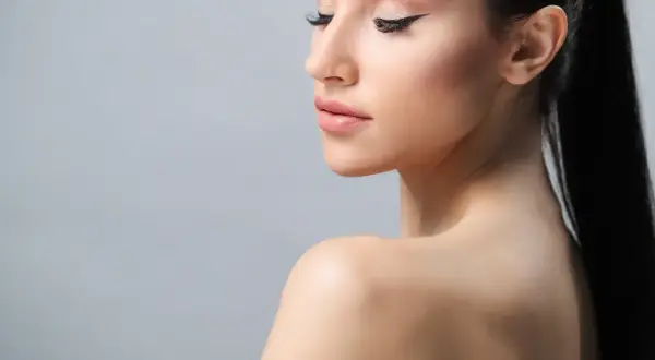 Portret kobiety z przedłużanymi rzęsami i makijażem.