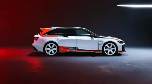 Białe Audi RS6 GT z pomarańczowymi akcentami i czarnymi pasami, gotowe do wyścigu.