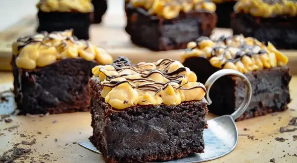 Saftige schoko brownies mit cremiger Topping und Schokodrizzle, verlockend dekoriert mit Schokostreuseln.