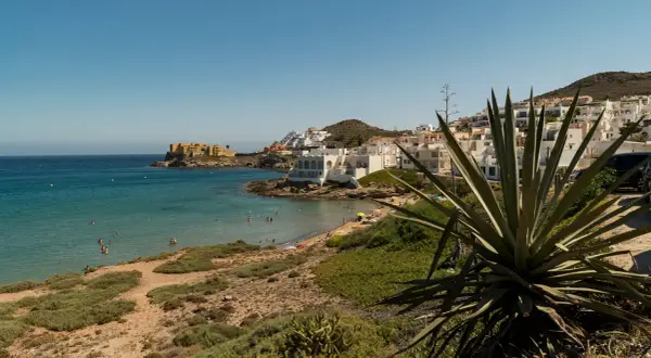 Costa de San José con casas blancas, playa y mar turquesa. Ideal para ver qué ver en San José y disfrutar del sol.
