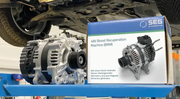 Un alterno démarreur SEG Automotive 48V est présenté à côté de sa boîte.