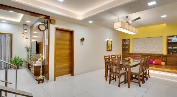 A modern dining room with a wooden table and chairs, featuring a sleek tile placement on the floor.