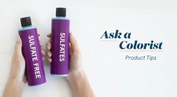 Manos sostienen dos botellas moradas: una dice "SULFATE FREE" y la otra "SULFATES". Aprende cómo saber si un champú tiene sulfatos.