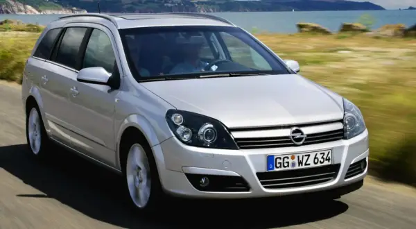 Srebrne kombi Astra H 1.7 CDTI jedzie wzdłuż malowniczego wybrzeża.