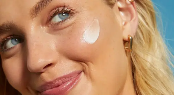 Viso di donna con crema all'acido salicilico come usarlo per una pelle luminosa.