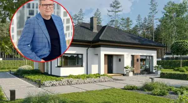 Mężczyzna w garniturze obok nowoczesnego domu jednorodzinnego. Dowiedz się, ile kosztuje budowa małego domu jednorodzinnego.