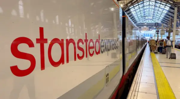 Stansted Express to Londyn – najtańszy sposób na podróż z lotniska. Pociąg czeka na pasażerów z bagażami.
