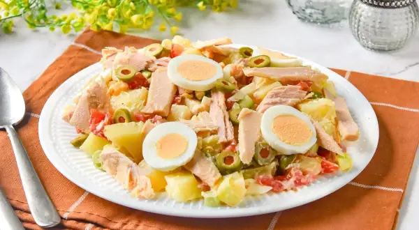 Sabrosa ensalada de patatas de la abuela con atún, huevo duro y aceitunas. Un plato casero que evoca recuerdos.