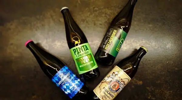Cztery butelki piwa, w tym niemieckie piwo Paulaner Oktoberfest.