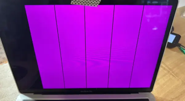 Uszkodzony ekran MacBook Pro wyświetla pionowe fioletowe pasy.